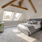 A newly completed loft conversion in a British home featuring Velux windows and modern decor.