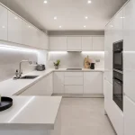 A beautiful modern space demonstrating perfect kitchen lighting without windows using reflective surfaces and bright LEDs.