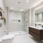 A beautiful modern windowless bathroom featuring advanced extraction and bright lighting to prevent dampness.