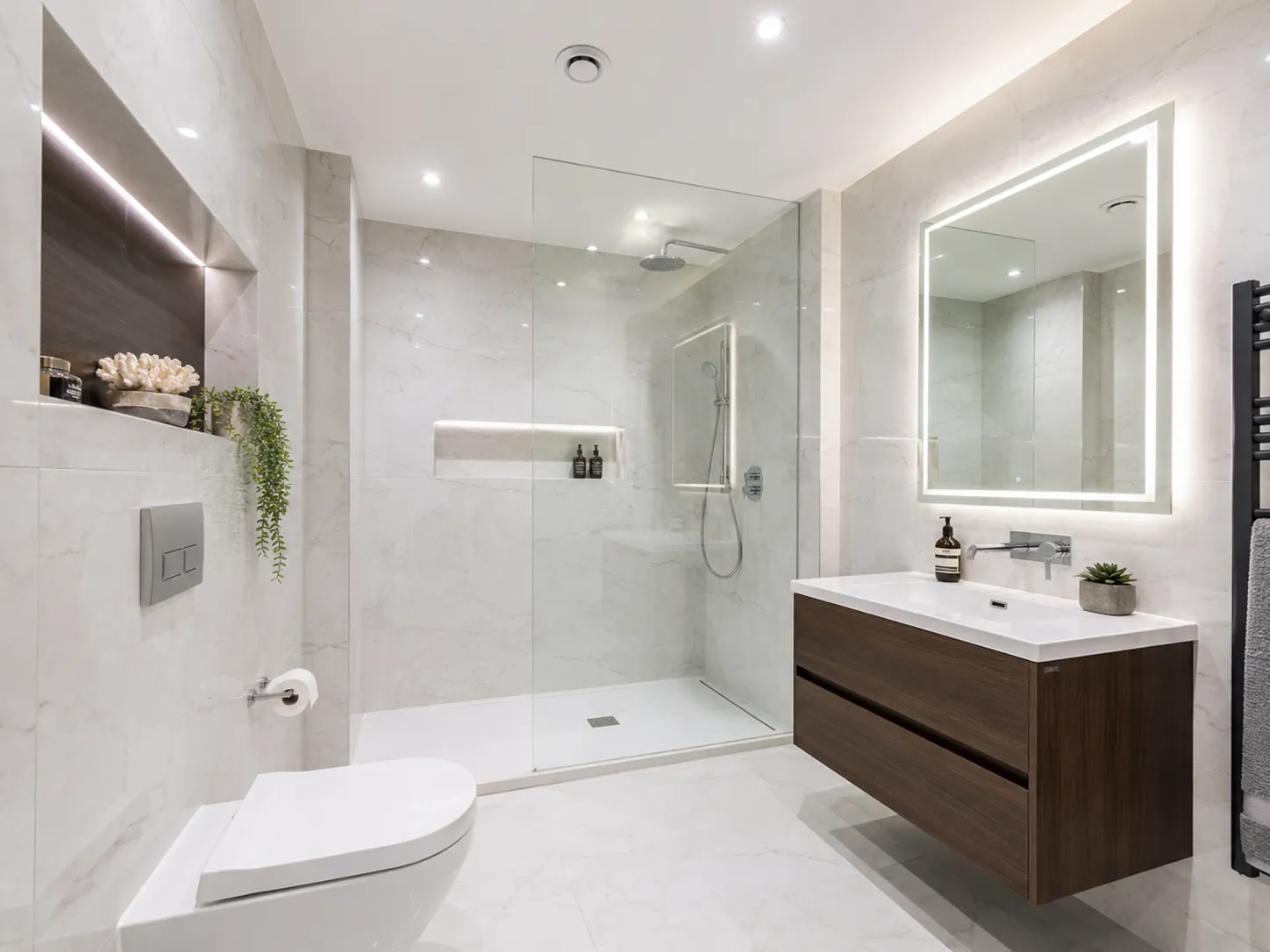 A beautiful modern windowless bathroom featuring advanced extraction and bright lighting to prevent dampness.